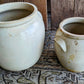 Two creamy coloured ceramic pots.