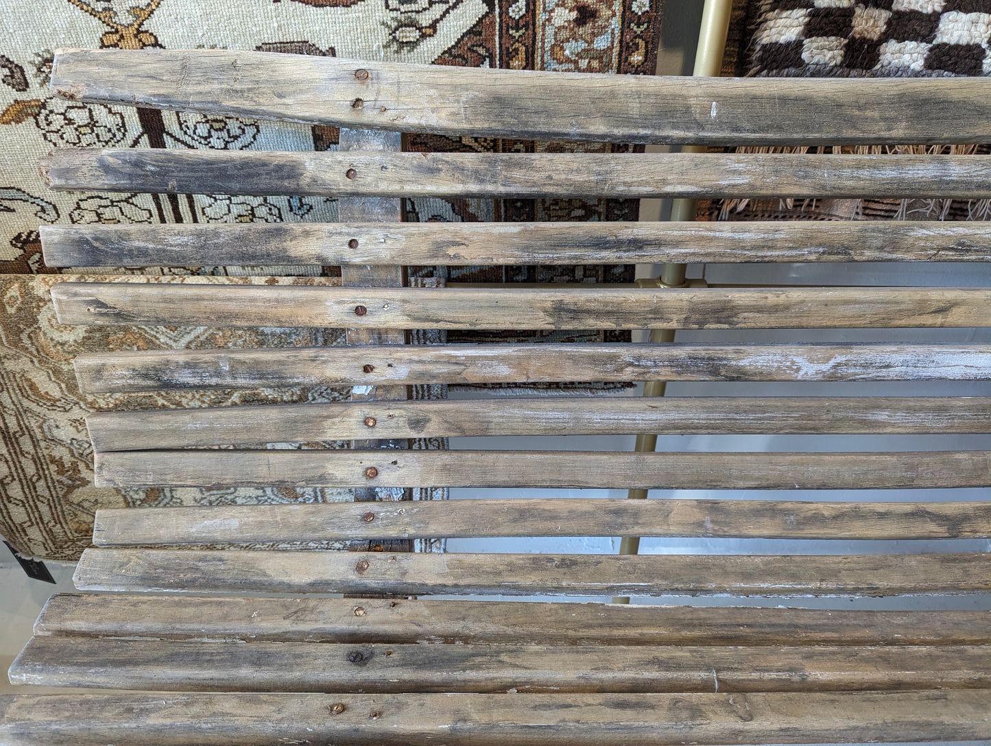 Long bench with weathered curvy whirkey rungs.